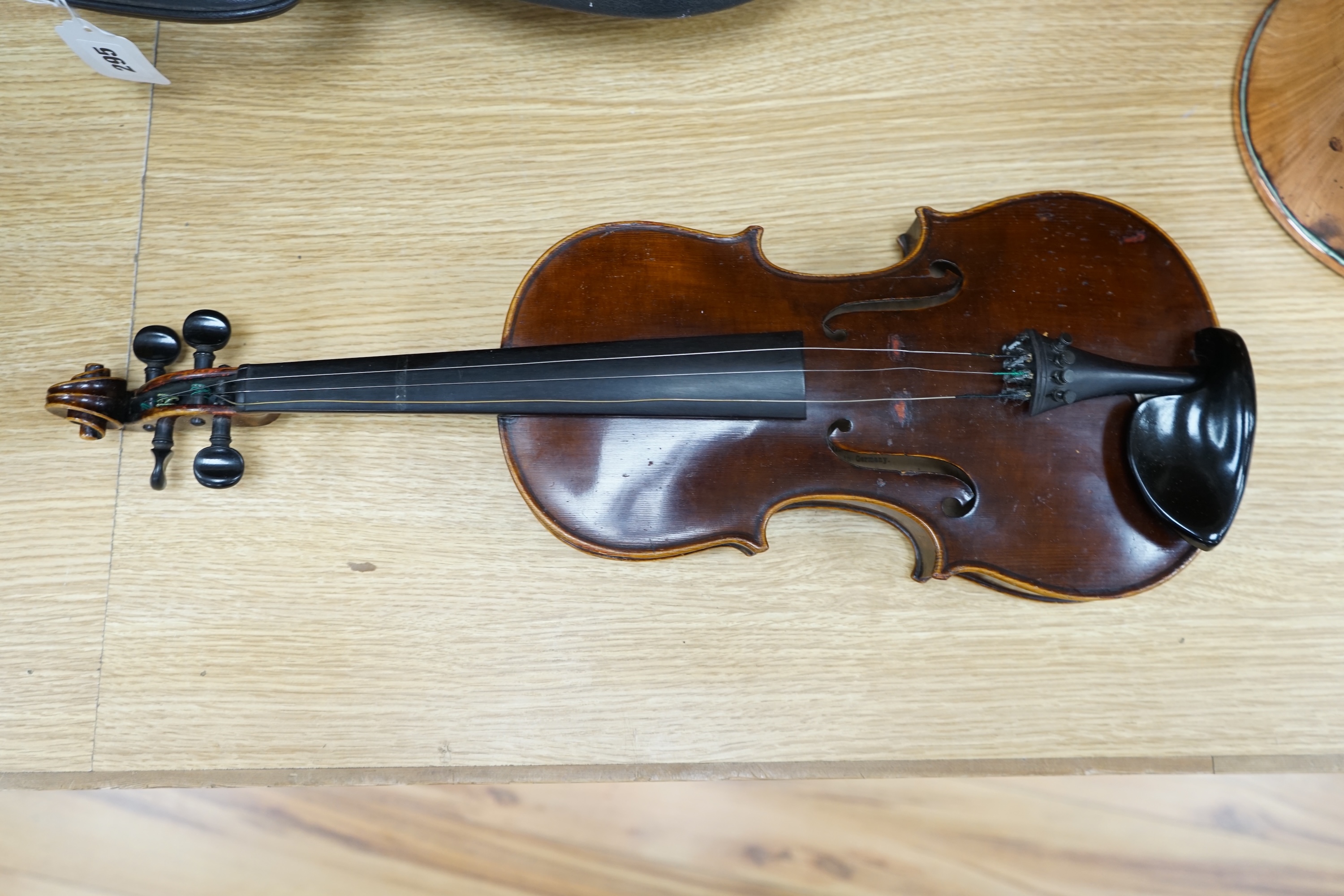 An early to mid 20th century violin, interior label reads ‘Copy of Antonius Straduarius made in Germany’, cased with bow, back measures 33.5cm. Condition - fair to good